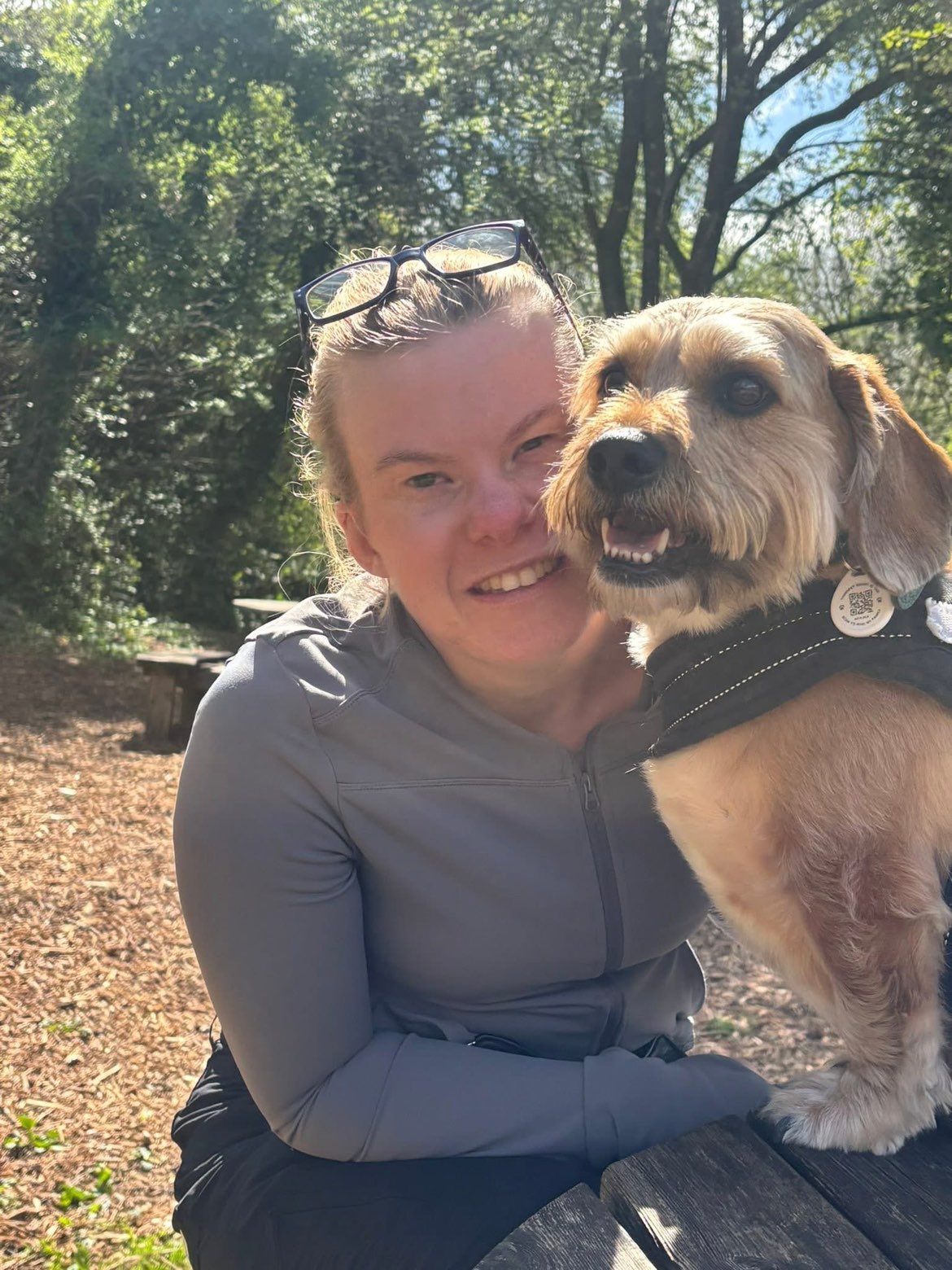 Zoë Castle smiling outdoors with her dog